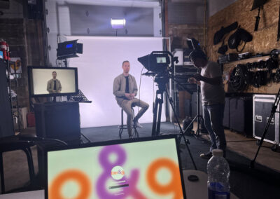 A man sitting in front of a camera on the set.